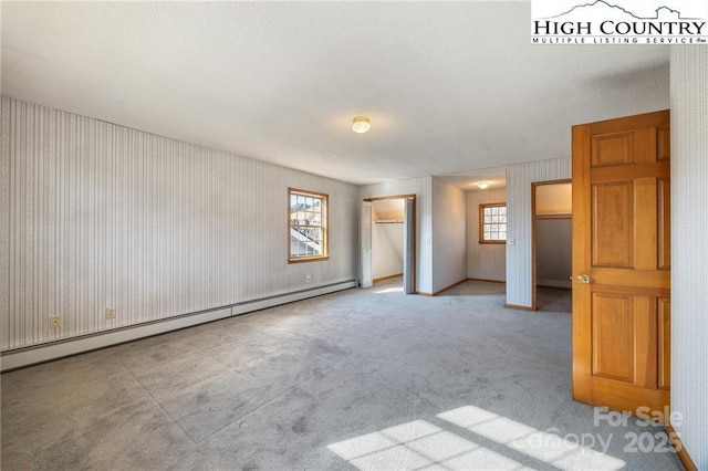 carpeted spare room featuring baseboard heating