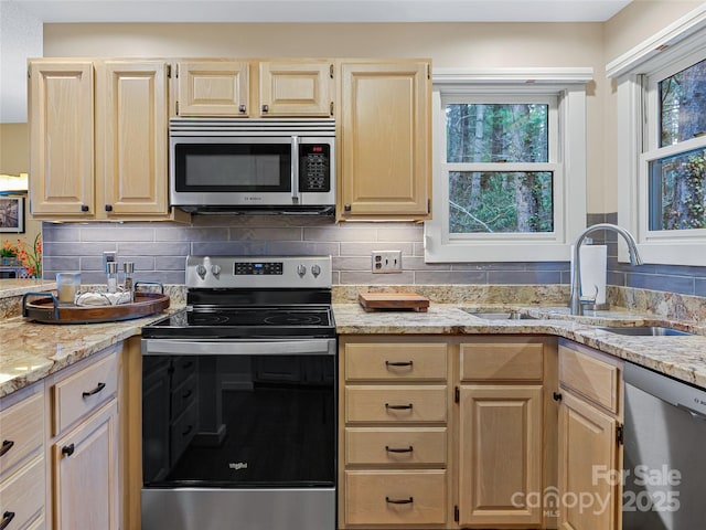 kitchen featuring a sink, decorative backsplash, light brown cabinets, and stainless steel appliances