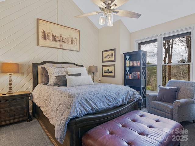 bedroom with carpet floors, lofted ceiling, ceiling fan, and wood walls