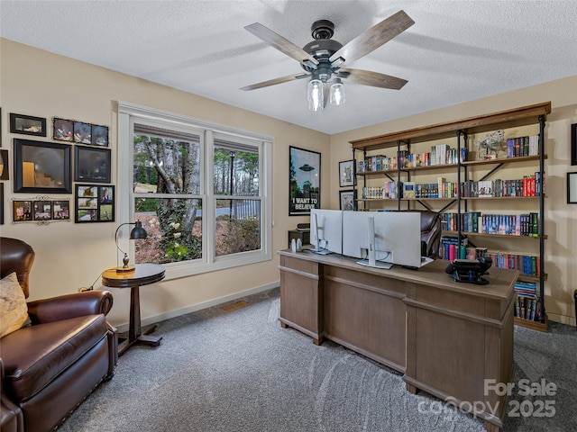 carpeted home office with visible vents, baseboards, a textured ceiling, and ceiling fan