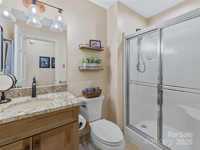 bathroom featuring vanity, toilet, and a shower stall