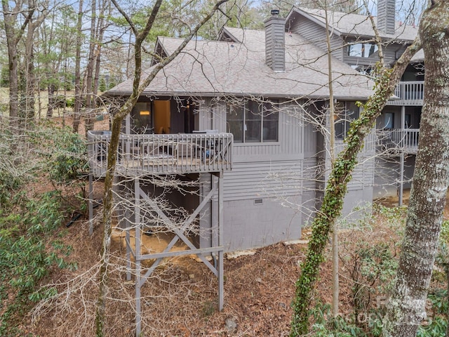 exterior space featuring a chimney, roof with shingles, and crawl space