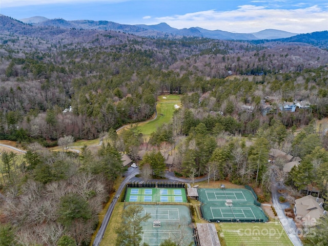 birds eye view of property with a wooded view and a mountain view