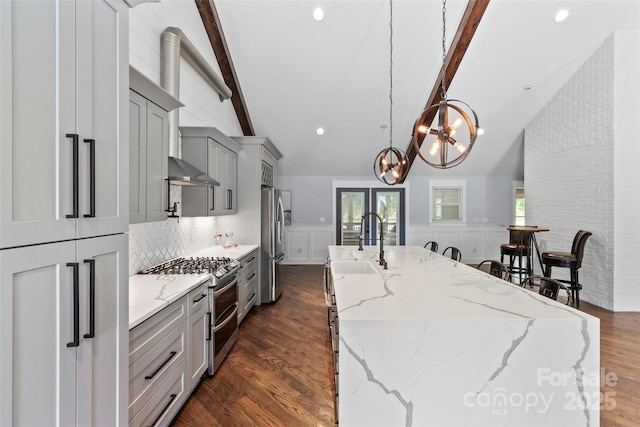 kitchen featuring lofted ceiling with beams, gray cabinets, stainless steel appliances, and a sink