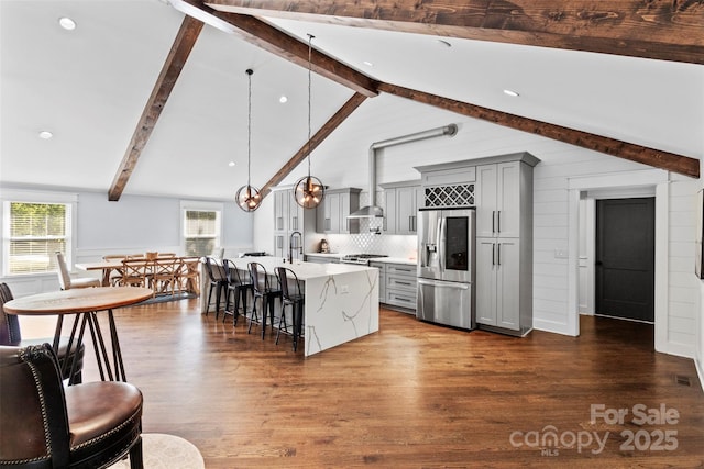 kitchen with a kitchen breakfast bar, dark wood-style flooring, gray cabinets, light countertops, and stainless steel refrigerator with ice dispenser