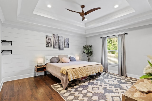 bedroom with baseboards, a raised ceiling, dark wood finished floors, ceiling fan, and recessed lighting