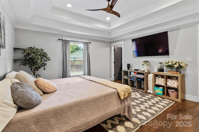 bedroom with ceiling fan, wood finished floors, a raised ceiling, and recessed lighting