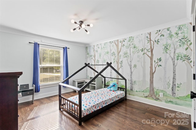 bedroom featuring baseboards, a notable chandelier, wood finished floors, and crown molding