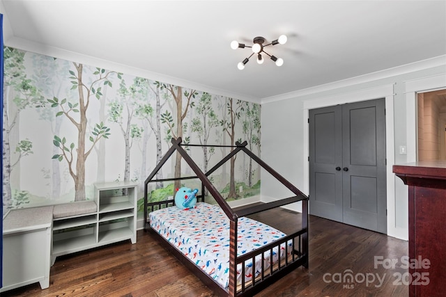 bedroom featuring ornamental molding, a closet, and wood finished floors