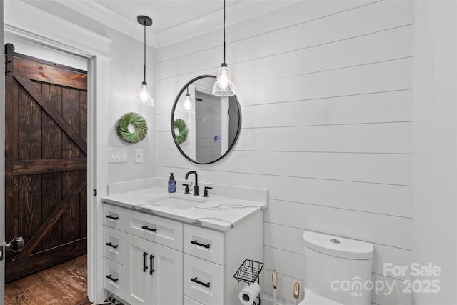 half bathroom featuring vanity, toilet, and wood finished floors