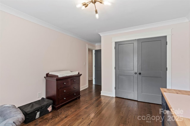 bedroom featuring baseboards, a closet, ornamental molding, and dark wood-style flooring