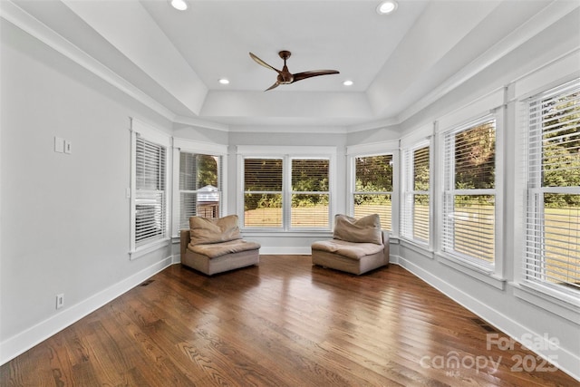 unfurnished sunroom with a raised ceiling, visible vents, and ceiling fan