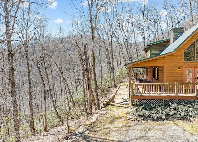 view of yard with a view of trees and a wooden deck