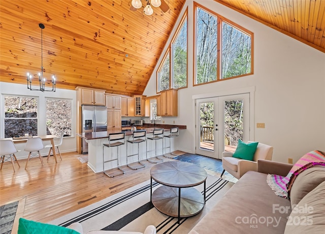 living room featuring french doors, an inviting chandelier, wood ceiling, light wood-type flooring, and baseboards