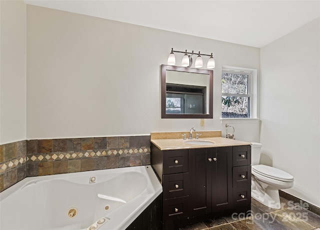 bathroom with a whirlpool tub, vanity, and toilet