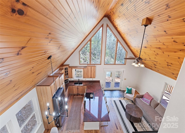 living area featuring high vaulted ceiling, wood ceiling, french doors, and wood finished floors