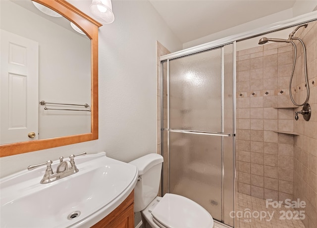 full bathroom with a shower stall, toilet, and vanity