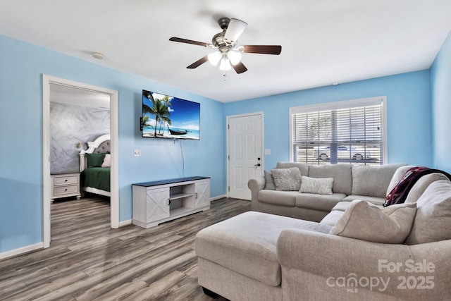 living room featuring wood finished floors, a ceiling fan, and baseboards