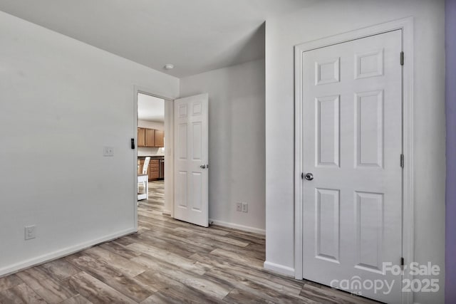 interior space with baseboards and wood finished floors