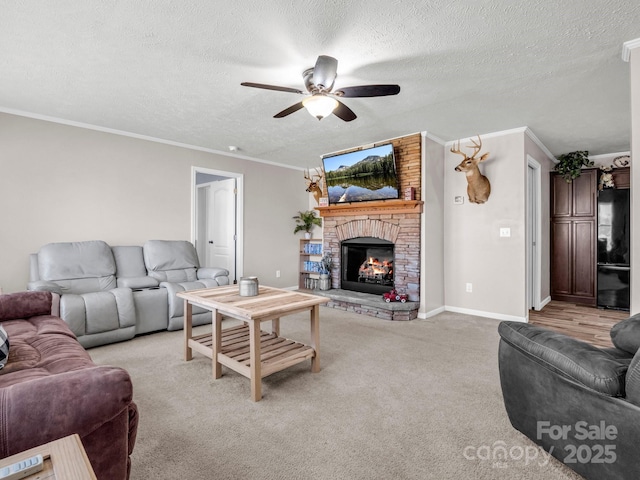 living area featuring a large fireplace, a ceiling fan, light colored carpet, a textured ceiling, and crown molding