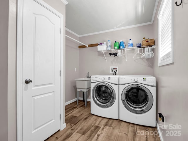 clothes washing area with laundry area, baseboards, independent washer and dryer, crown molding, and light wood-type flooring