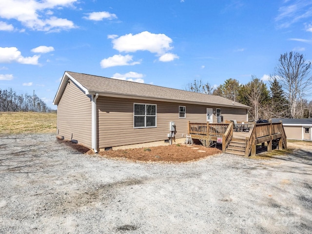 view of front of home featuring crawl space, roof with shingles, and a wooden deck