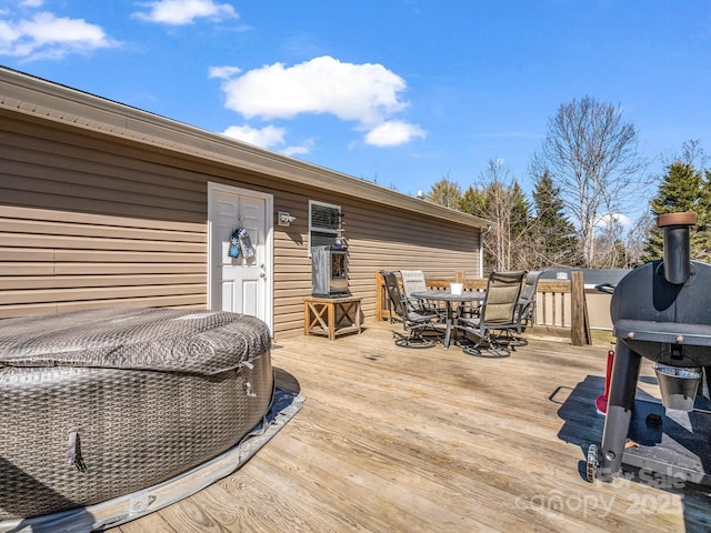 deck with outdoor dining space and a grill