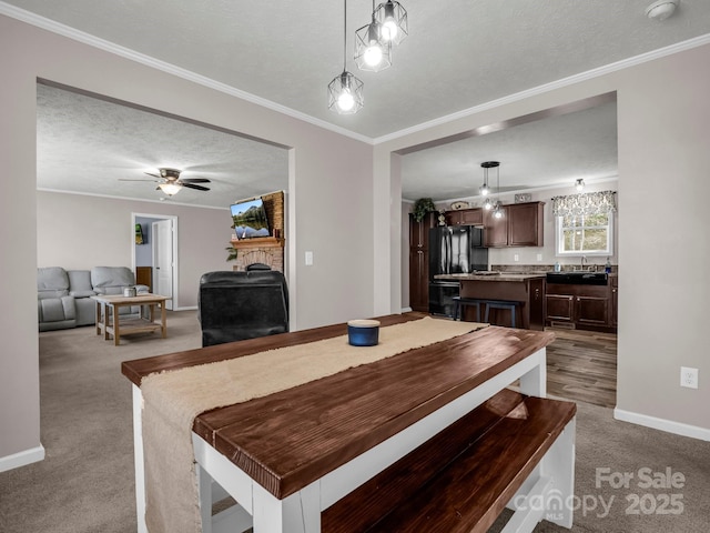 981 Gilliam Mountain Rd, Hendersonville, NC 28792 - carpeted dining room featuring baseboards, a textured ceiling, ornamental molding, a large fireplace, and ceiling fan
