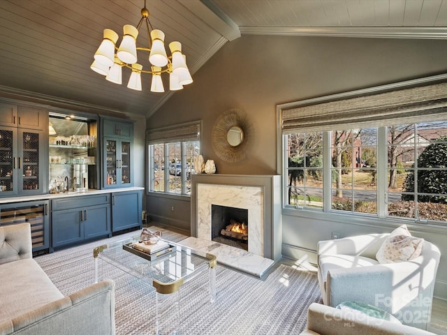 living area with vaulted ceiling with beams, wine cooler, a premium fireplace, ornamental molding, and a dry bar