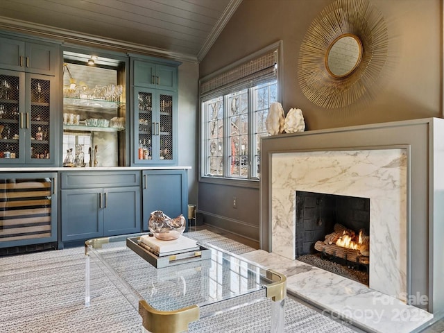 bar featuring a dry bar, baseboards, wine cooler, a premium fireplace, and crown molding