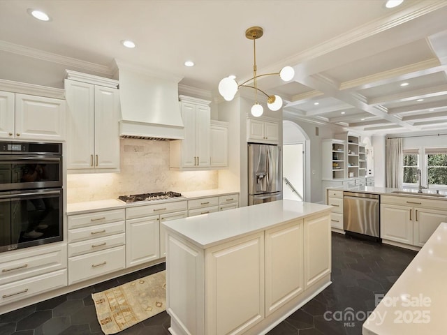 kitchen featuring arched walkways, premium range hood, a sink, light countertops, and appliances with stainless steel finishes