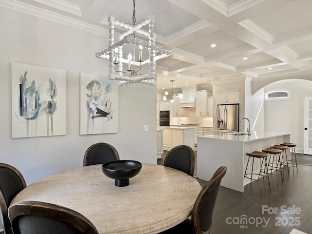 dining room featuring dark wood-type flooring, coffered ceiling, beam ceiling, and a notable chandelier