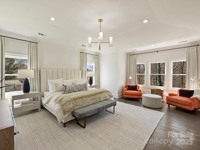 bedroom with a notable chandelier, multiple windows, wood finished floors, and recessed lighting