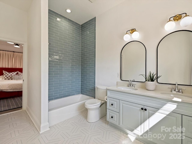 ensuite bathroom featuring tile patterned flooring, toilet, a sink, and ensuite bath