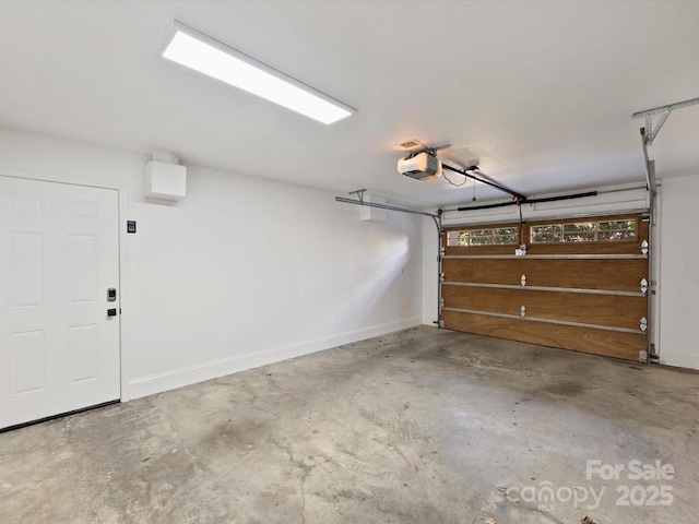 garage with a garage door opener and baseboards