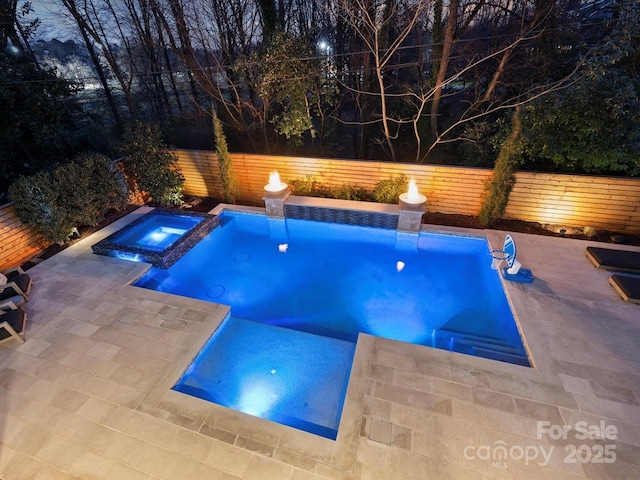 view of swimming pool with a fenced backyard, a pool with connected hot tub, and a patio