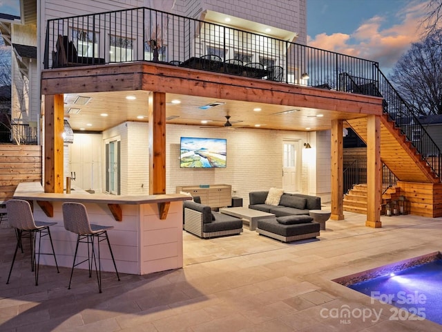 view of patio / terrace with an outdoor hangout area, outdoor dry bar, and stairs