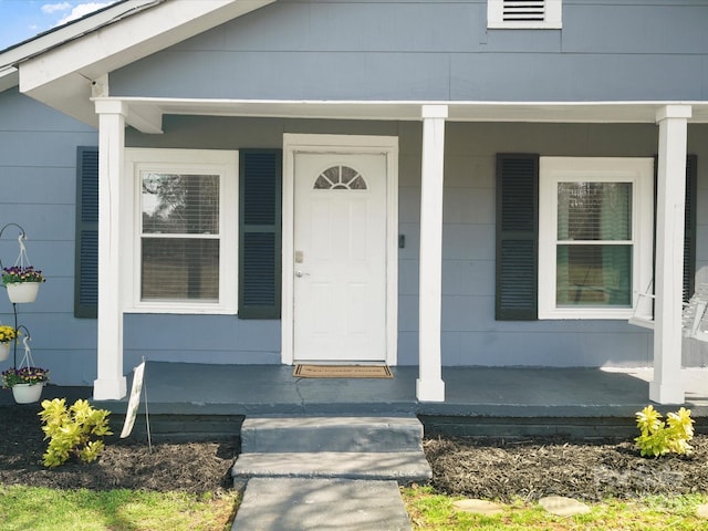 doorway to property featuring visible vents and a porch