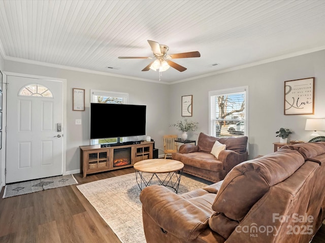 living area with dark wood-style flooring, visible vents, and crown molding