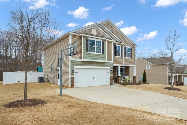 view of front of house with concrete driveway, central AC unit, fence, and a garage