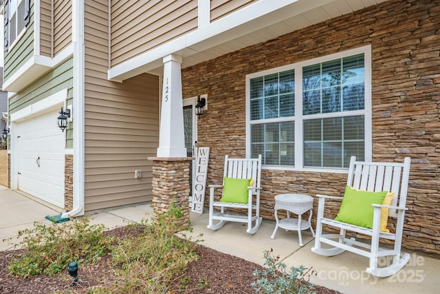 exterior space featuring stone siding, covered porch, and an attached garage