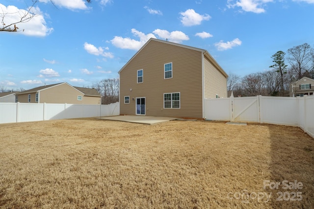 rear view of house with a gate, a patio area, a lawn, and a fenced backyard