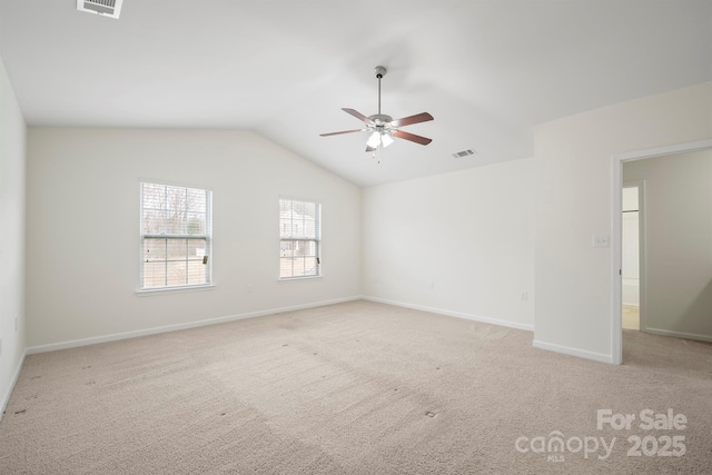 spare room featuring visible vents, baseboards, lofted ceiling, light colored carpet, and ceiling fan