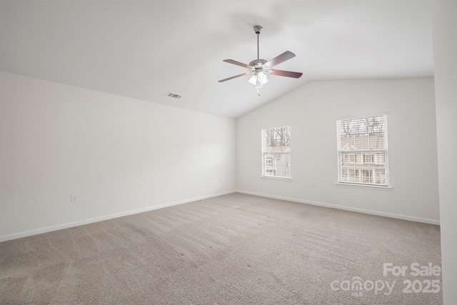 empty room with vaulted ceiling, visible vents, baseboards, and carpet floors