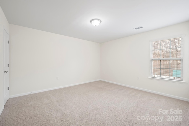 spare room with light carpet, visible vents, and baseboards