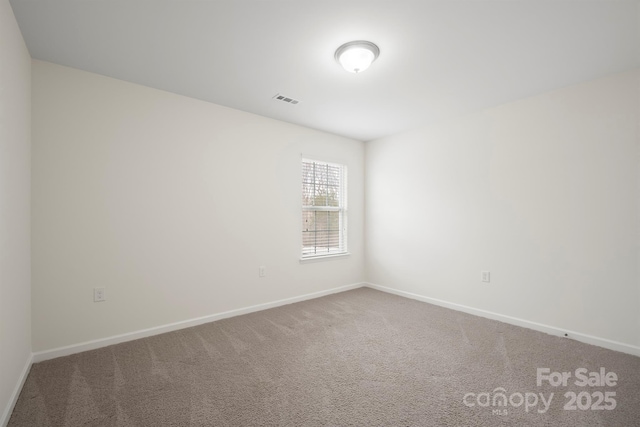 empty room featuring visible vents, baseboards, and carpet floors