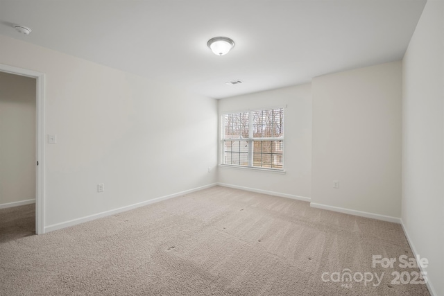 spare room with visible vents, baseboards, and carpet flooring