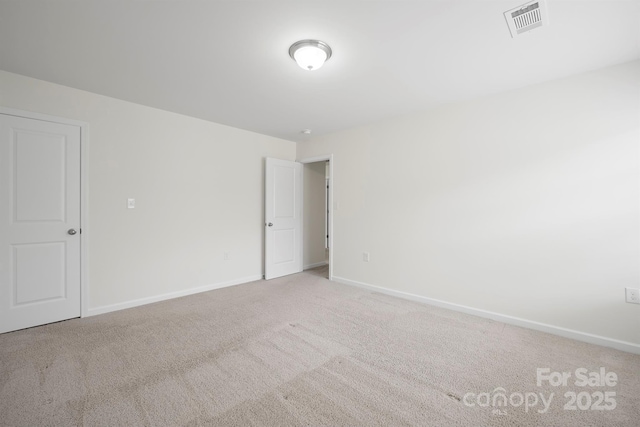 carpeted empty room featuring baseboards and visible vents