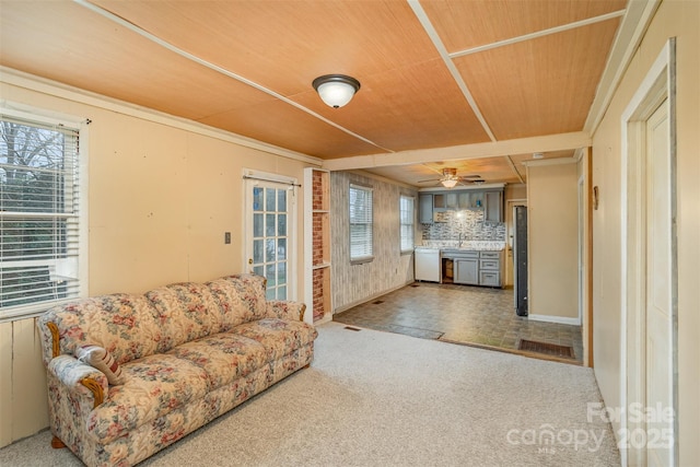 living room featuring plenty of natural light, carpet flooring, wood ceiling, and ceiling fan