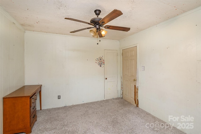 empty room featuring crown molding, a ceiling fan, and light carpet